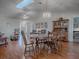 Open-concept dining area with a skylight, stylish lighting, and hardwood floors at 305 Ranchwood Dr, Leesburg, FL 34748