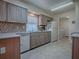 Well-lit kitchen featuring laminate floors, modern appliances, tile backsplash and wood cabinets at 305 Ranchwood Dr, Leesburg, FL 34748