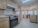 Bright kitchen featuring wooden cabinets, granite countertops, and a view into the dining area at 305 Ranchwood Dr, Leesburg, FL 34748