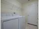 Functional laundry room with washer, dryer, shelving, and door to outside or garage at 305 Ranchwood Dr, Leesburg, FL 34748