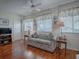 Cozy living room features a ceiling fan, laminate floors, and natural light from the windows at 305 Ranchwood Dr, Leesburg, FL 34748