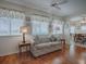 Inviting living room with windows, ceiling fan and laminate floors, leading into the dining room at 305 Ranchwood Dr, Leesburg, FL 34748