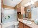 Bathroom featuring a shower-tub combo, mirrored wall, and a sink with a countertop at 308 Emmalee Pl, The Villages, FL 32162