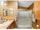 Bathroom featuring a shower, mirrored wall, and a sink with a countertop at 308 Emmalee Pl, The Villages, FL 32162