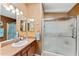 Bathroom featuring a shower, mirrored wall, and a sink with a countertop at 308 Emmalee Pl, The Villages, FL 32162