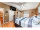 Comfortable bedroom featuring wood floors, a ceiling fan, and a wall-mounted TV for relaxed living at 308 Emmalee Pl, The Villages, FL 32162