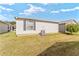 View of the side exterior features a window with gray shutters and an A/C unit on a green lawn at 308 Emmalee Pl, The Villages, FL 32162