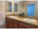 Bathroom featuring double sinks, vanity with a tile countertop, and a large mirror at 3356 Blaise Ter, The Villages, FL 32163