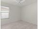 A bedroom featuring light gray wood-look floors, ceiling fan, and a window to let in natural light at 3356 Blaise Ter, The Villages, FL 32163