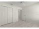 A bedroom featuring light gray wood-look floors, ceiling fan, and a double-door closet at 3356 Blaise Ter, The Villages, FL 32163