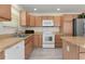 Kitchen showcasing stainless steel appliances, light wood cabinets, and countertops at 3356 Blaise Ter, The Villages, FL 32163