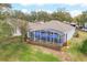 Rear exterior view of the house featuring a screened-in patio and landscaping at 3782 Avon Ct, Clermont, FL 34711