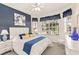 Comfortable bedroom with a blue accent wall, natural light, and a queen-sized bed at 3782 Avon Ct, Clermont, FL 34711