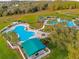 Aerial view of a sparkling community pool and lounge area with lush landscaping and palm trees at 3782 Avon Ct, Clermont, FL 34711