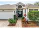 Close-up of a house's front entrance and two-car garage, highlighted by an arched entryway and landscaping at 3782 Avon Ct, Clermont, FL 34711