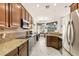 Kitchen featuring stainless steel appliances, granite counters, dark cabinets, tile backsplash, and marble flooring at 3782 Avon Ct, Clermont, FL 34711