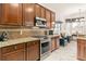 Kitchen featuring stainless steel appliances, granite counters, dark cabinets, tile backsplash, and adjacent sitting area at 3782 Avon Ct, Clermont, FL 34711