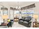 Living room with large bay window, comfortable seating, chandelier lighting, and marble flooring at 3782 Avon Ct, Clermont, FL 34711