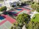 Aerial view of multiple fenced tennis courts with trees and landscaping at 3782 Avon Ct, Clermont, FL 34711