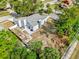 A bird's eye view of the home and backyard with a wooded perimeter. Includes a concrete patio with a firepit at 3901 Woodglade Cv, Winter Park, FL 32792