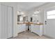 Bright bathroom featuring dual vanities and an exterior access door at 3901 Woodglade Cv, Winter Park, FL 32792