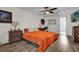 Bedroom featuring an orange bedspread, neutral walls and a bright window at 3901 Woodglade Cv, Winter Park, FL 32792