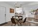 Dining area with modern chandelier, round glass table and direct access to the kitchen at 3901 Woodglade Cv, Winter Park, FL 32792