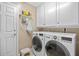 Laundry room with white front loading washer and dryer and storage cabinets at 39131 Griffin Lndg, Lady Lake, FL 32159