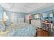 Bright main bedroom with light blue walls, tray ceiling, wood floors, and white furniture at 39131 Griffin Lndg, Lady Lake, FL 32159