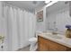 Clean and functional bathroom featuring a shower-tub, toilet, and a single sink vanity with oak finish and great lighting at 406 Bramble Way, Minneola, FL 34715