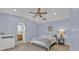 Cozy bedroom featuring a ceiling fan, recessed lighting, an arched doorway leading to an en-suite bathroom, and light blue walls at 406 Bramble Way, Minneola, FL 34715