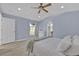 Bright bedroom boasts a ceiling fan, recessed lights, neutral paint, a window view, and arched entryway to an en-suite bathroom at 406 Bramble Way, Minneola, FL 34715