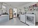 Well-equipped laundry room featuring modern washer, dryer, shelving, and utility sink at 406 Bramble Way, Minneola, FL 34715