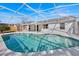 Screened pool with a patio space that overlooks the backyard, perfect for outdoor entertaining and relaxation at 406 Bramble Way, Minneola, FL 34715