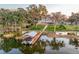 Aerial shot showcases the home and boat dock, highlighting lake access with lush landscaping on a sprawling green lawn at 415 Carman Dr, Leesburg, FL 34748