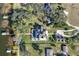 Aerial view showcases the grand estate, pool, detached garage, lush landscaping, and private boat docks at 415 Carman Dr, Leesburg, FL 34748