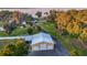 Aerial view of garage with multiple bays, long driveway, and lakeside scenery, offering space and natural beauty at 415 Carman Dr, Leesburg, FL 34748