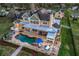 Aerial view of the backyard with a pool, patio, lounge chairs, and manicured landscaping at 415 Carman Dr, Leesburg, FL 34748