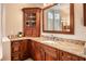 Spacious bathroom featuring granite counters, custom dark wood cabinets, sink, and vanity mirror at 415 Carman Dr, Leesburg, FL 34748