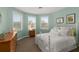 Bright bedroom features three windows, neutral carpet and white iron bed frame at 415 Carman Dr, Leesburg, FL 34748