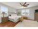 Sun-filled bedroom features wood floors, ceiling fan, and neutral decor at 415 Carman Dr, Leesburg, FL 34748