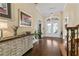 Inviting foyer features hardwood floors, decorative console table, and glass double doors at 415 Carman Dr, Leesburg, FL 34748