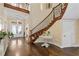 Spacious foyer featuring a curved staircase, high ceilings, and beautiful wood floors at 415 Carman Dr, Leesburg, FL 34748