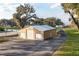 Aerial view of a garage with multiple bays, surrounding landscape, and a driveway leading to the property at 415 Carman Dr, Leesburg, FL 34748