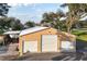 Spacious garage with multiple bays, a lean-to, and ample parking, perfect for car enthusiasts and storage needs at 415 Carman Dr, Leesburg, FL 34748