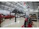 Car Garage with a car lift showcasing multiple vehicles in a well-lit space, perfect for automotive enthusiasts at 415 Carman Dr, Leesburg, FL 34748