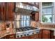 Gourmet kitchen with stainless steel range hood, granite countertops, and dark wood cabinets creating a perfect balance of style and functionality at 415 Carman Dr, Leesburg, FL 34748