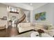 Bright living room with hardwood floors, white sofa, and staircase to the second story at 415 Carman Dr, Leesburg, FL 34748