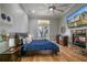 Beautiful main bedroom featuring hardwood floors, ceiling fan, stone fireplace and access to balcony at 415 Carman Dr, Leesburg, FL 34748