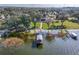 Aerial shot of boat house and waterfront property with dock, trees, and manicured lawn at 415 Carman Dr, Leesburg, FL 34748